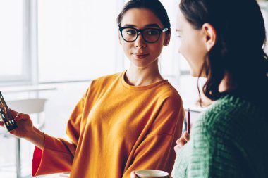 Smartphone için yetenekli öğrenci bilgilerini gösteren gözlük güzel kadın tasarımcısında. İki girişimci sosyal ağ birlikte office iç duran yazı tartışıyor