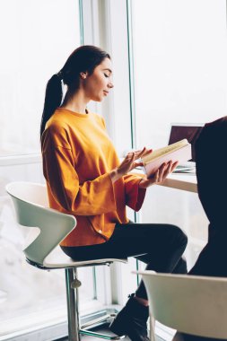 İki şık öğrenci eğitim semineri yer coworking yılında modern netbook oturan birlikte hazırlama kitap ile. Çatı katı iç ortak görev çalışmaya işbirliği yaratıcı genç kadın