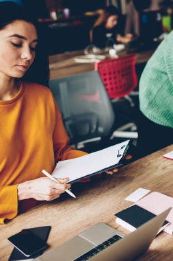 Yeni Tasarım Eskizler togeter üzerinde profesyonel çalışanlarla çalışma sırasında smartphone ayakta vasıl okul sırası üzerinde konuşurken not defteri metin bilgileri yazma esmer saçlı genç kadın