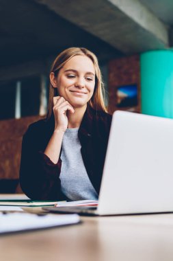 Ofiste çalışırken dizüstü bilgisayarda yaratıcı fikirler hakkında ders veren başarılı bir kadın grafiker tasarımcısı. Netbook 'ta sarı saçlı ve iş haberleri okuyan pozitif öğrenci.
