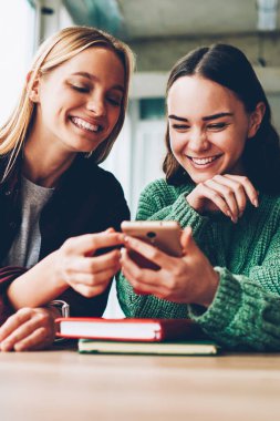 Internet Web siteleri sosyal medya hayat molası sırasında zevk komik video izleme sırasında gülerek mutlu arkadaşlarım. İki neşeli kadın blogcular smartphone aygıt üzerindeki olumlu yorumlar okuma