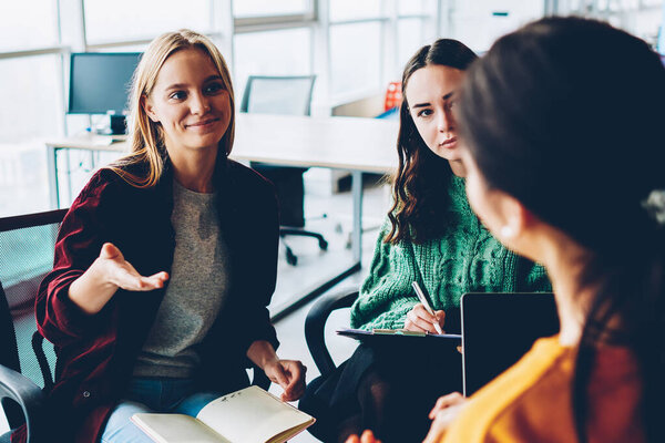 Творческие молодые женщины обсуждают некоторые рабочие вопросы во время консультаций по новому дизайнерскому проекту в офисе. Студенты обсуждают бизнес-план и командную работу во время мозгового штурма в университете
