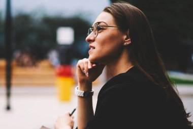 Boş vakit Street ve çalışma programı planlama daha iyi görüş için serin gözlük genç sevimli esmer kadın. Uzakta, otururken sokak ve düşünme seyir tatlı hippi kız