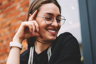 Neşeli bayan gazeteci gülüyor ve heyecanlı hissediyor. İyi iş çıkardıktan sonra dışarıda ders kitabı ile oturup, görüş düzeltmesi için gözlüklü mutlu hippi kız hayatın tadını çıkarıyor.
