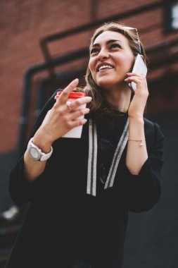 Genç başarılı bayan öğrenci cep telefonuyla arkadaşını arıyor. Gezintiye çıkmış, pozitif gülümseyen bir kadın. Dışarıdaki uluslararası cep telefonu konuşmaları sırasında şakadan gülüyor.