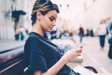 İş yerinden önemli e-postalar alırken akıllı telefondan harita tarifi arayan ciddi bir bayan gezgin, modern cep telefonuyla iletişim kuran ve boş zamanların tadını çıkaran hippi kız.