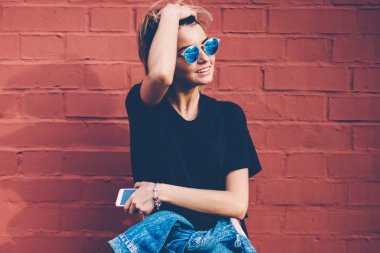 Başarılı bir bayan öğrenci, yüzünde olumlu bir gülümsemeyle, tanıtım geçmişinin yanında bekleyen bir arkadaş, neşeli hippi kız sokakta takılıyor, dışarıda boş zaman geçiriyor.