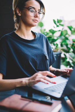 Kafası karışmış genç bir yönetici, rahat bir sokak kafede modern bir dizüstü bilgisayar üzerinde çalışıyor, düşünceli hippi kız sosyal medya ağında netbook üzerinden bilgi alışverişi yapıyor.