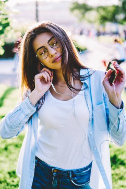 Kulaklık ve mobil Park, pozitif hippi kız zevk ses ve ritim içinde hareket çalma listesi şarkıları ile dinlendirici dinleniyor üzerinden dinleme favori müzik dans Eyewear genç kadın