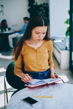 Düşünceli hippi kız 20 'li yaşlarda çalışma alanında ilginç bir kitap okuyor. Düşünceli düşünceli kadın içeride edebiyattan zevk alıyor. Kafeteryada muayeneye hazırlanan düşünceli kız öğrenci.