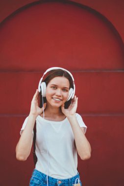 Gülümseyen kadın melodinin yarım boy portresi kulaklıkla yeni şarkı listesinden keyif alan neşeli kadın açık havada radyo yayını şarkıları dinleyen modern stereo ekipmanları boş zamanlarında kullanan kadın.