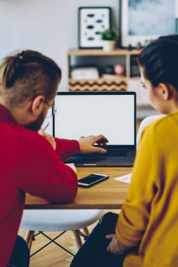 Kadın ve erkeğin dizüstü bilgisayarda video izlediği arka plan görüntüsü oturma odasında ekran görüntüsü oluşturması, çift web mağazasından eşya seçerek ev içi internet üzerinden alışveriş yapıyor.