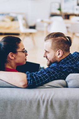 Romantik bir çiftin evdeki rahat koltuğunda oturması, aşık bir hipsterın kanepede yanındaki sevgilisine bakması, ev içi dizüstü bilgisayar kullanması.