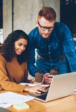 Kıvırcık saçlı dijital dizüstü bilgisayar kullanan studio eğitim sırasında kendi tasarım projesi için profesyonel öğretmen izlerken mutlu afro Amerikan öğrenci verimli çalışması için internet'e bağlı