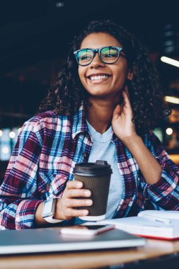 Mola sırasında ele gider için lezzetli kahve tutarken kitap edebiyat arsa üzerinde düşünme rüya gibi gülümseyen Afro-Amerikan öğrenci. Yaratıcı fikirler üzerinde durulması kıvırcık saçlı teen olumlu koyu derili