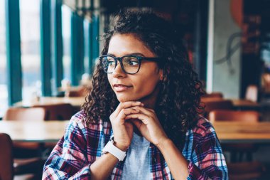 Pencereden dışarı bakıyor ve yeni eğitim proje ve çalışma planı dijital bilgisayar başında oturan düşünme düşünceli Afrikalı-Amerikalı genç kadın bağlı 4 g internet şık coworking uzayda