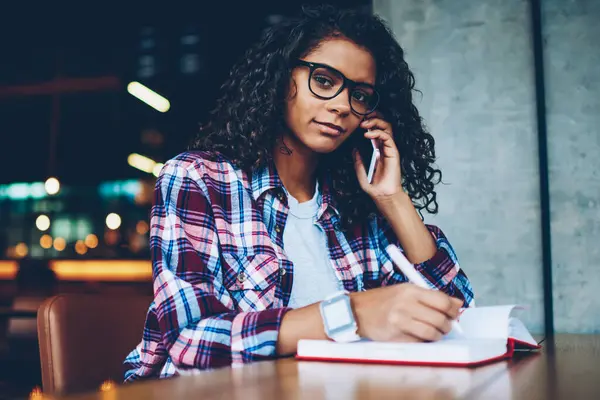 Not defteri metin bilgileri yazarken işleci ile n smartphone söz kıvırcık saçlı sevimli koyu tenli öğrenci portresi. Afro Amerikan hippi kız cep üzerinde iletişim