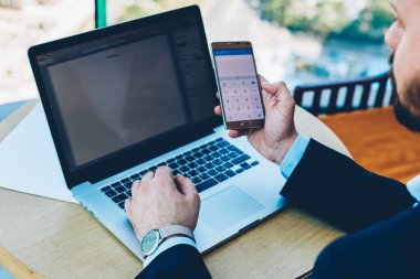 Finansal raporlar sahte office iç oturma alanı ile modern netbook üzerinde posta yoluyla alınan kontrol için smarphone üzerinde hesaplama yapma formal giyim giymiş işadamı Resim kırpılmış