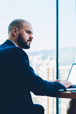 Yetenekli emin erkek girişimci bir modern dizüstü bilgisayar oturan kendi iş projesi geliştirme resmi giyim düşüncesinde giyinmiş bağlı 4 g için Internet. Boş ekran alanı için mali Haberler