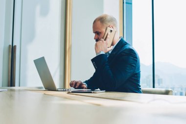 Mali tablo dijital smartphone cep telefonu ile iş ortağı ile modern netbook çalışma ve ofiste tabloda toplantı oturan e-posta kontrol ederken geliştirme hakkında konuşurken şirketinin erkek sahibi