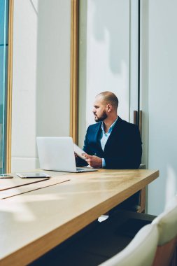 Pencereden dışarı bakarken dizüstü bilgisayar kendi ofisinde oturan elinde muhasebe raporları ile birlikte ciddi bir iş adamı. Tablo toplantıda modern netbook çalışan emin kurumsal Direktörü