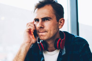 Yakışıklı durulması akıllı bu kapalı cep telefonunuzun mobil konuşmayı ile sokulgan yolu ile uygulama geliştirici. Dalgın yaratıcı erkek blogger kafede otururken Smartphone'da konuşuyor