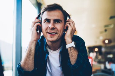 Boş vakit kapalı ve favori radyo istasyonu online kulaklık ile müzik yaratıcı erkek blogger gülümseyen yakışıklı. Neşeli hipster adam eğlence müzik ve iyi bir ruh hali ile zevk