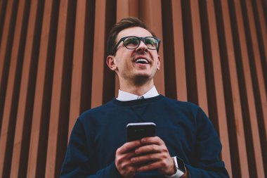 Son moda gözlük sosyal ağ takipçileri ile yaz yürüyüş sırasında sohbet sırasında eğlenmek genç yakışıklı neşeli adam. Mutlu hippi herif iyi bir ruh hali ile kentsel ayarı boş zaman zaman harcama