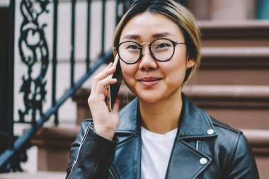 Merdivenlerde serbest zaman sırasında Çinli kız açık havada şehir merkezinde telefonda konuşurken bankacılık Eyewear oturan hizmeti işleci ile mobil konuşmayı olumlu Asya kız öğrenci