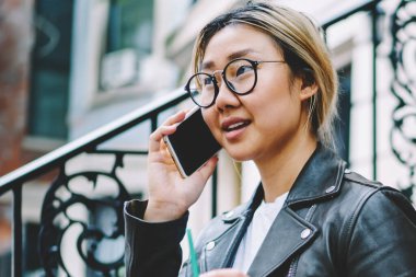 Gitmek için genç Çinli kız arkadaşıyla telefonda konuşurken merdivenlerde oturan operatör buzlu kahve holding ile telefon görüşmesi sırasında banka hesabı kontrol Eyewear ciddi genç Asyalı kadın