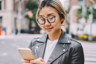Genç Asyalı kız arkadaş sohbet online açık havada City, sarışın Çinli kadın üzerinden mobil şehir merkezinde geziniyor kafe hakkında bilgi okuma vakit ise gözlük manifatura geribildirim içinde