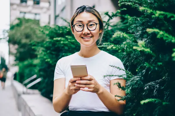 Pozitif genç Asyalı kadın sosyal ağlar multimedya dosyaları boş sırasında zaman şehir merkezinde paylaşımı Eyewear mutlu Çinli kız arkadaş online mobil, sohbet şehir merkezinde dinlenme