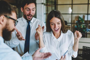 Mimar çizimlerine ve kitaptaki bilgilere bakan ve iyi iş çıkarmanın kazandığını hisseden mutlu meslektaşlar, bir grup erkek ve kadın tasarımcı şirket ofisinde işbirliğinden zevk alıyorlar.