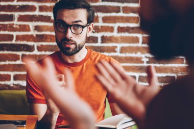 Ciddi optik gözlük alan coworking içinde toplantı sırasında arkadaşıyla tartışmaya genç adam sakallı. Birlikte laptop oturan ortak proje üzerinde meslektaşı ile strateji tartışmaya öğrenci