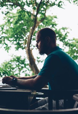 Düşünceli hippi, netbook aracılığıyla arkadaşıyla sohbet ediyor. Asya gezisi sırasında kafede oturuyor. Konsantre olmuş erkek serbest yazar, terasta dizüstü bilgisayar kullanarak ağlarda bilgi arıyor.