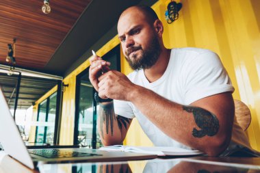 Düşünceli erkek öğrenci dizüstü eğitsel izlerken ödev yazmak için bilgi analiz ile kötü bağlantı, serbest üzerinde çalışmak için yazılım güncelleştirmesi için bekleyen mutsuz hipster adam üzgün