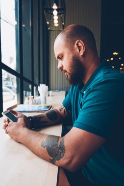 Sosyal ağlar içerik ara kafeterya, yaratıcı erkek bolgger takipçileri ile bir paylaşım cep telefonu ve wifi kullanarak multimedya sohbet ile smartphone ile yeni güncelleştirmeleri denetlemeyi genç hipster adam