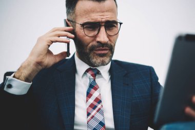 Veritabanını çevrimiçi istek-e doğru Smartphone cep telefonu ile operatör ise dijital tablet kontrol emin deneyimli iş adamı. Başarılı olgun gurur CEO'su hesap bankacılık ve cep telefonu üzerinde konuşurken yapımı