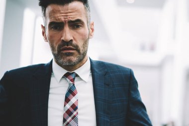 Yarım uzunluk portre emin gurur CEO 50 yaşında kameraya bakıyor. Başarılı olgun işadamı formal giyim ofis iç kapalı duran giyinmiş. Finans şirketinin erkek sahibi