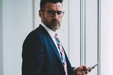 Formal giyim 4 g internet ayakta iş bilgilerinizi için tanıtım alanının yakınında bağlı smartphone aygıt üstünde posta kontrol emin olgun girişimci yarım uzunluk portre giymiş