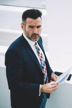 Üstten görünüm muhasebe raporları elinde tutan formal giyim giymiş başarılı emin girişimci 50 yaşında. Ciddi olgun gurur CEO'su kağıt belgeleri bankacılığı ile portresi