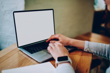 Dizüstü bilgisayarda blog içeriği için yayın yapan bir kadının kesilmiş görüntüsü. Modern netbook üzerinde çalışan kadın birlikte çalışma ofisinde kablosuz internete bağlı olarak uygulama yüklüyor