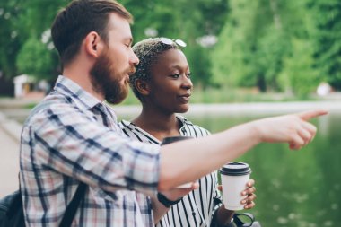 Sakallı adamın kenara çekilip yeşil parktaki sakin gölün yanında dururken içkili zenci kız arkadaşla konuşması.