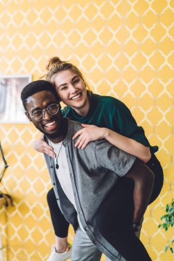 Gözlüklü, çok ırklı, neşeli erkekler evde sırtüstü gülen genç kadınlar yetiştirerek eğleniyorlar.