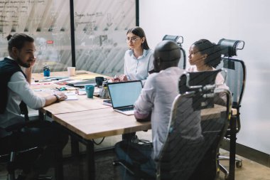 Camdan çok ırklı, hırslı, zeki iş adamları modern çalışma alanındaki dağınık masa etrafında şirket hakkında strateji tartışmalarına katılıyorlar.