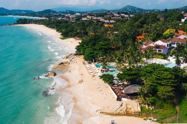 Turkuaz berrak deniz suyuyla beyaz kumsal manzarası. Kumsalda otelleri olan resimli gölün kuş bakışı panoramik manzarası. Tayland 'da nüfuslu bir ada