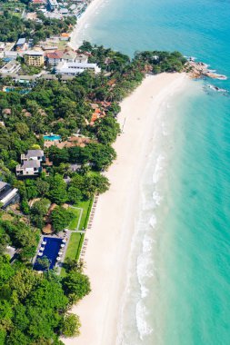 Turkuaz berrak deniz suyuyla beyaz kumsal manzarası. Kumsalda otelleri olan resimli gölün kuş bakışı panoramik manzarası. Tayland 'da nüfuslu bir ada