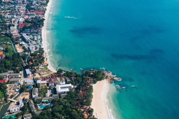 Turkuaz berrak deniz suyuyla beyaz kumsal manzarası. Kumsalda otelleri olan resimli gölün kuş bakışı panoramik manzarası. Tayland 'da nüfuslu bir ada