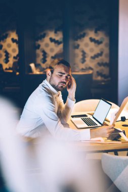 Resmi takım elbiseli stresli işadamlarının penceresinden sorunların çözümü üzerinde çalışırken gece ofis alanına dokunan evrak işlerine bakarken bakın.