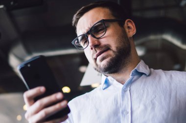 Şaşırmış erkek profesyonel patron mobil hücre modunda kurumsal sorunları çözmek için mobil e-posta alırken, ticaret web sitesinde para alışverişini kontrol eden kafası karışmış finans uzmanı